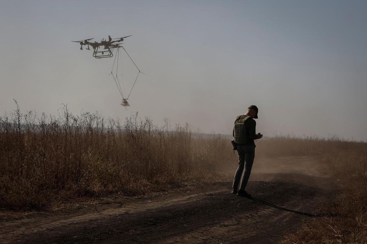 A member of the volunteer organization 'Postup' operates a drone during demining near the town of Derhachi