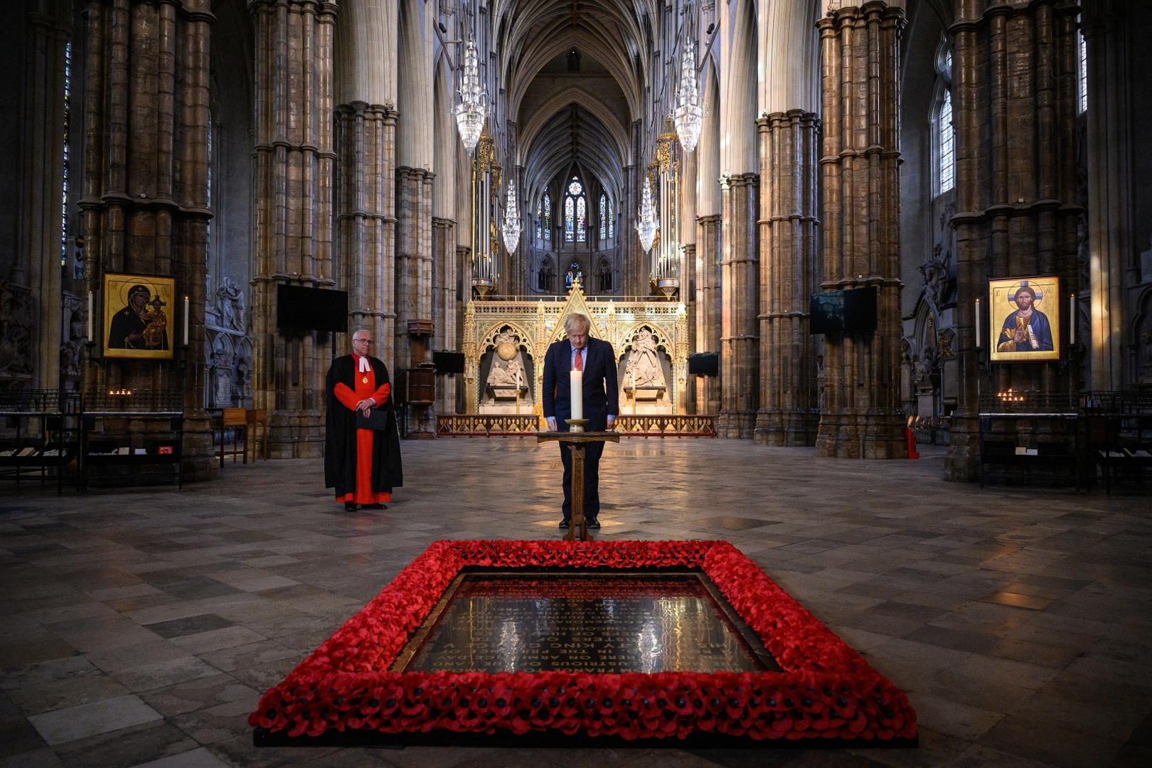 VE Day 75th Anniversary The Dean of Westminster, the Very Reverend Dr David Hoyle (left) looks on as Prime Minister Boris Johnson lights a candle at the Grave of the Unknown Warrior in Westminster Abbey in London, ahead of commemorations to mark the 75th anniversary of VE Day. Leon Neal  Photo: PA Images/PIXSELL