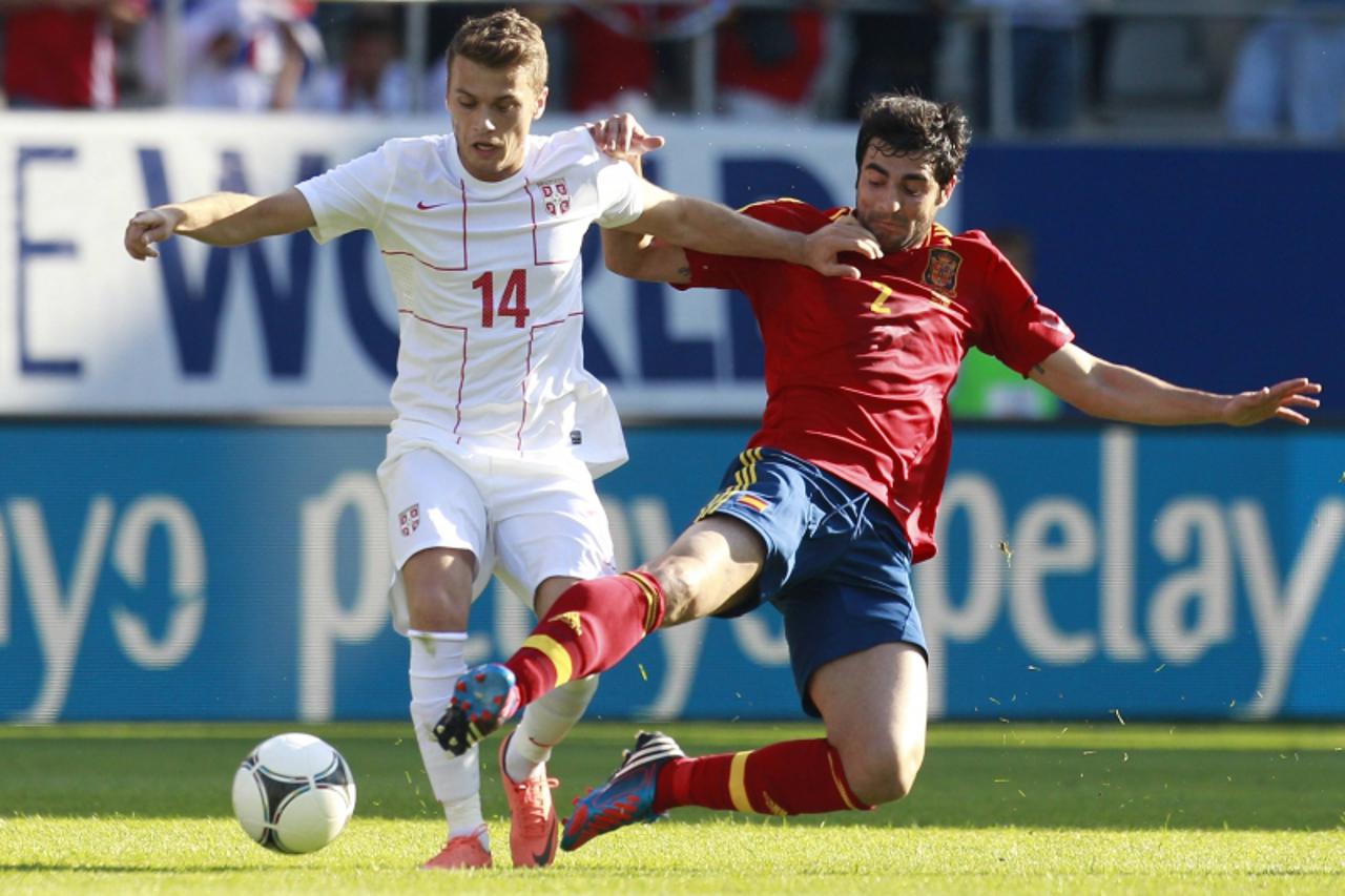 'Spain\'s Raul Albiol (R) challenges Serbia\'s Adem Ljajic during their friendly soccer match in St. Gallen May 26, 2012.  REUTERS/Miro Kuzmanovic (SWITZERLAND - Tags: SPORT SOCCER)'