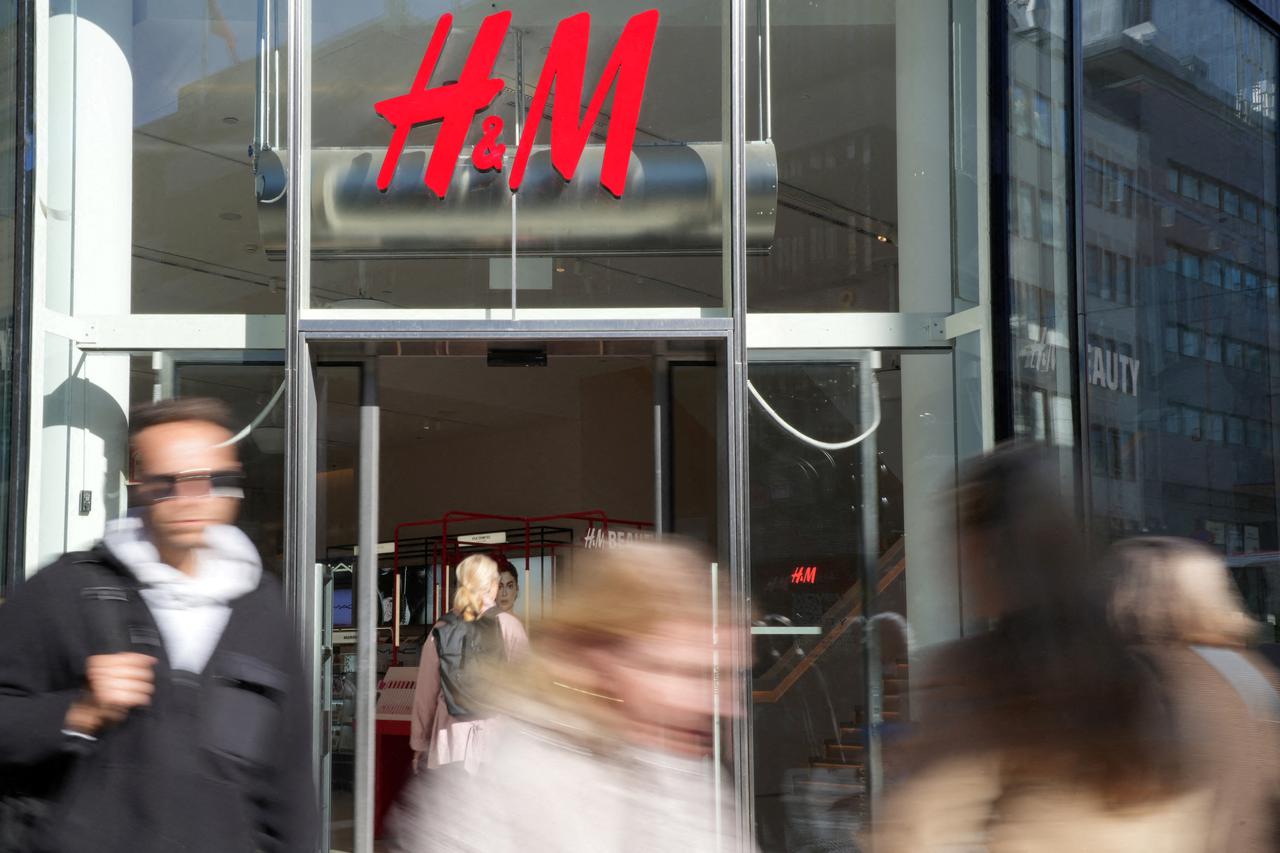 FILE PHOTO: Pedestrians walk past a branch of H&M, in Stockholm