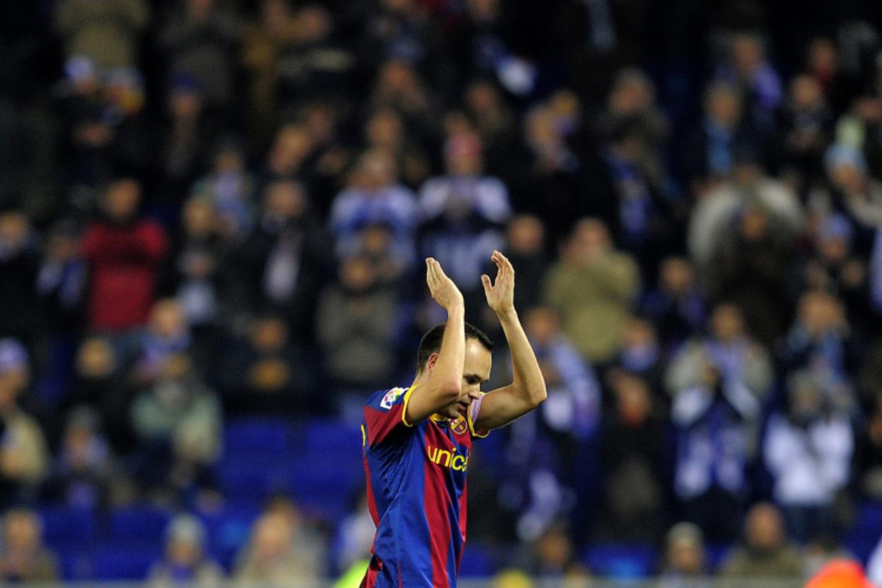 \'Barcelona\'s midfielder Andres Iniesta  applauds Espanyol\'s supporters during the Spanish league football match Espanyol RDC vs FC Barcelona on December 18, 2010 at the Cornella-El Prat stadium in 
