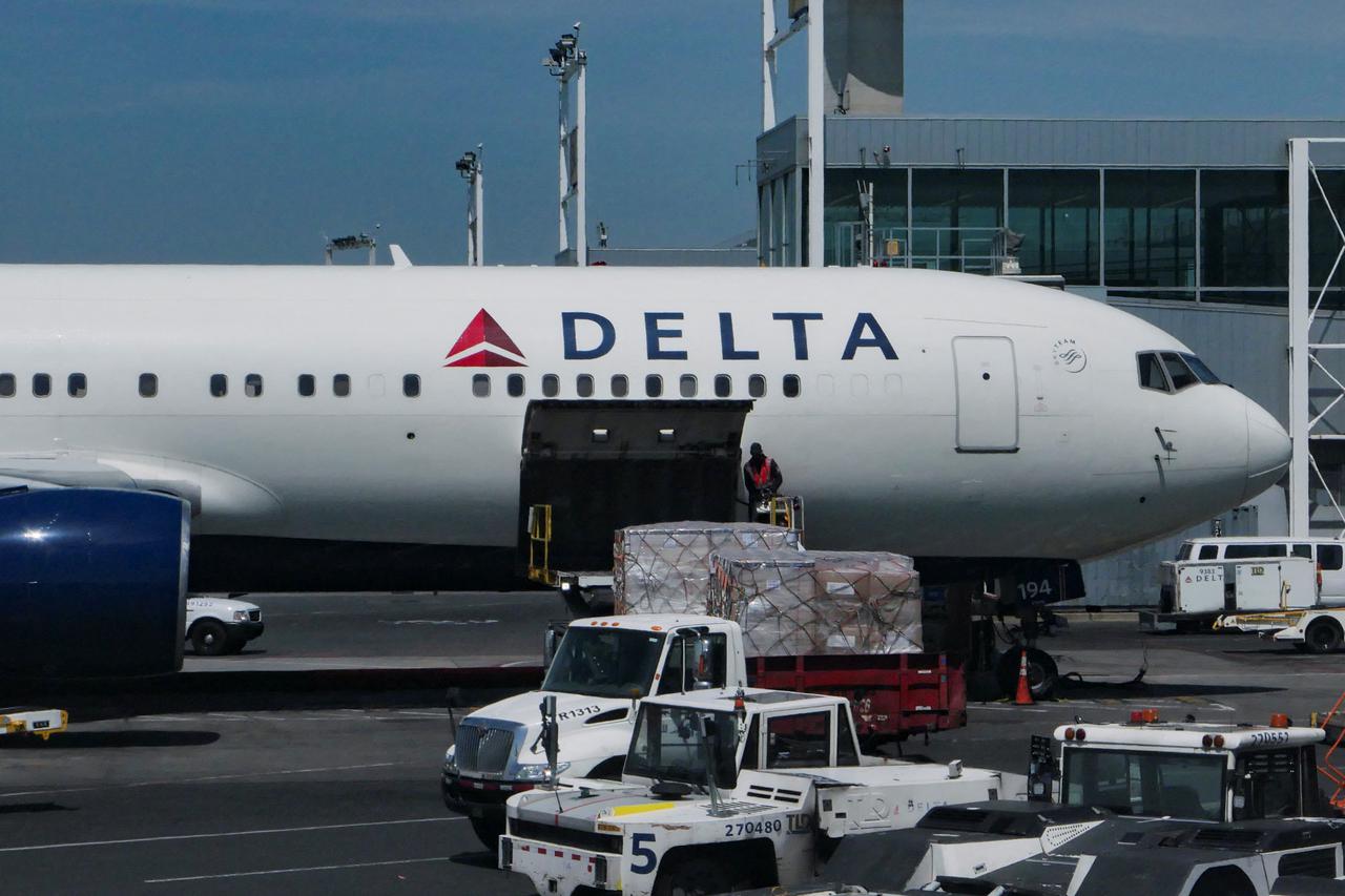 A staff uploads packages on Delta Air Lines plane at John F. Kennedy International Airport in Queens, New York City