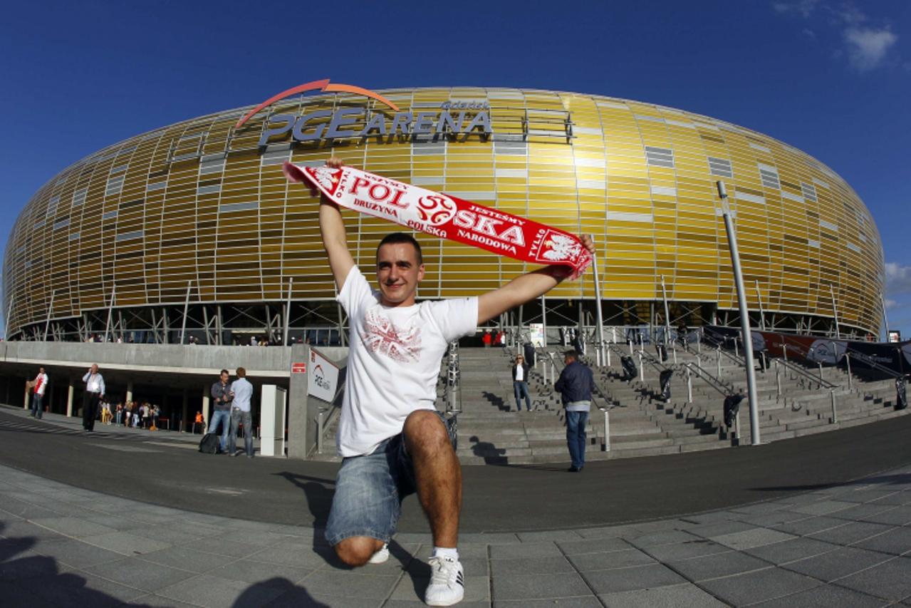 'A fan of Poland\'s soccer team poses with scarf before their international friendly soccer match against Germany outside of the newly built stadium for the Euro 2012 European Championships in Gdansk 
