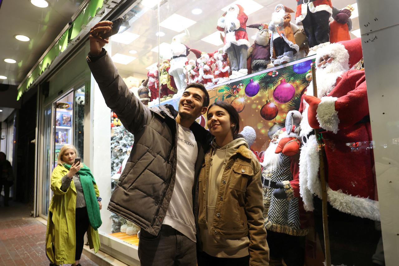 Iranians take a selfie at a Christmas store in Tehran