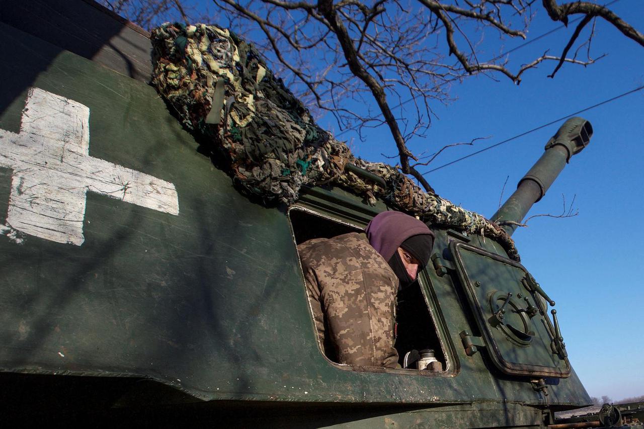 Ukrainian servicemen look on from 2S3 Akatsiya self-propelled howitzer at their position in a frontline in Donetsk region