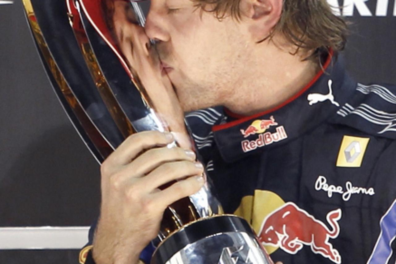\'Red Bull Formula One driver Sebastian Vettel of Germany kisses the trophy after winning the Abu Dhabi F1 Grand Prix at Yas Marina circuit in Abu Dhabi November 14, 2010. Vettel became Formula One\'s