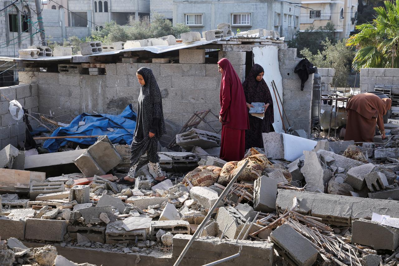 Women inspect as a house damaged in an Israeli strike lies in ruin, amid the ongoing conflict between Israel and the Palestinian Islamist group Hamas, in Rafah