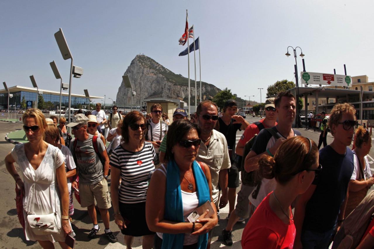 'Pedestrians wait to enter to Spain at its border with the British Colony of Gibraltar in front of the Rock (rear) in Gibraltar, southern Spain August 3, 2013. British Foreign Office Political directo