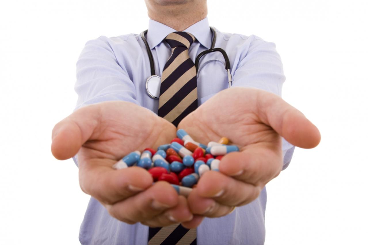 'businessman holding a lot of pills in his hands (selective focus)'