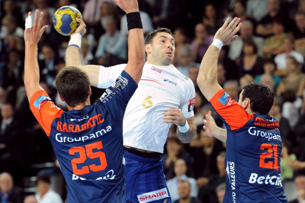 'Hamburg\'s Blazenko Lackovic (C) vies with Montpellier\'s French Luka Karabatic (L) and Branislav Obradovic (R) during the European Champions League handball match Montpellier vs Hamburg at the Arena