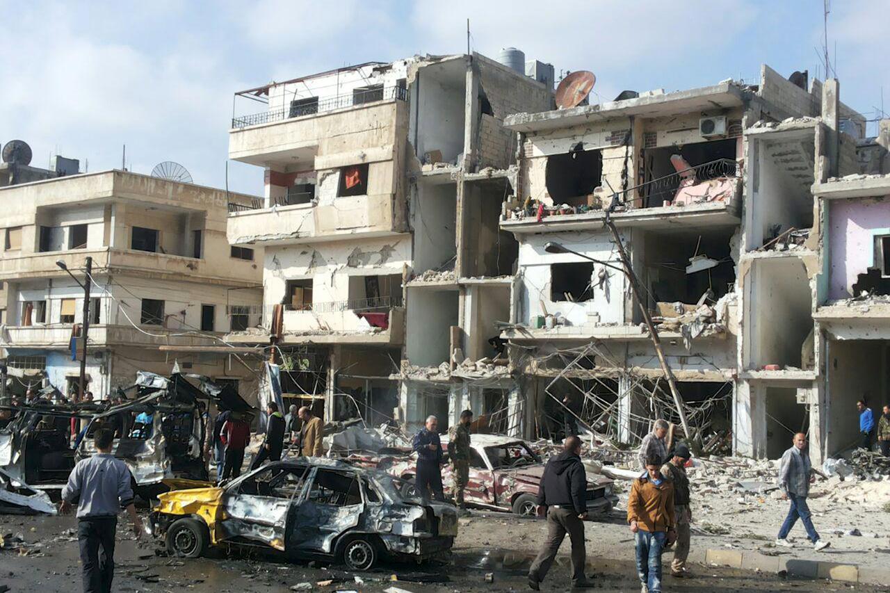 Syrian army soldiers and civilians inspect the site of a two bomb blasts in the government-controlled city of Homs, Syria, in this handout picture provided by SANA on February 21, 2016. REUTERS/SANA/Handout via Reuters ATTENTION EDITORS - THIS PICTURE WAS