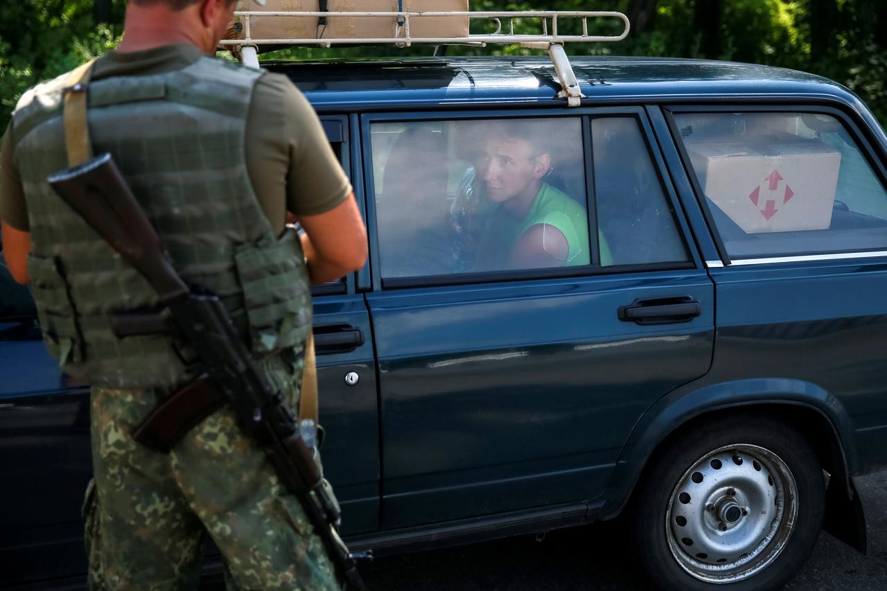 A Ukrainian serviceman checks a car at a checkpoint near Slaviansk, in Donetsk region, Ukraine, June 29, 2016.  REUTERS/Gleb Garanich