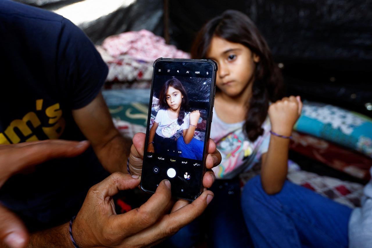 Gazan father marks his children with bracelets amid airstrikes in Khan Younis