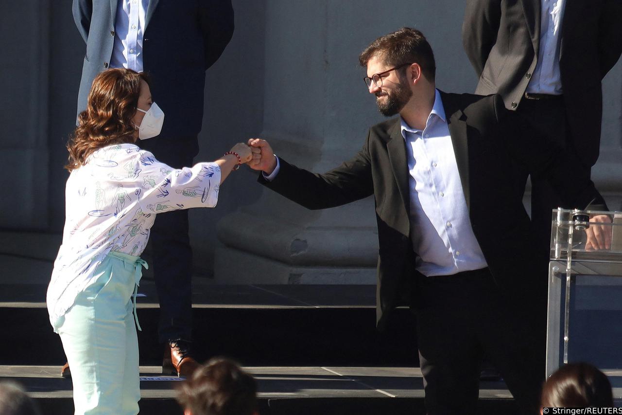 Chilean President-elect Gabriel Boric bumps fists with his future Mining Minister,  Marcela Hernando during the presentation of his first cabinet in Santiago