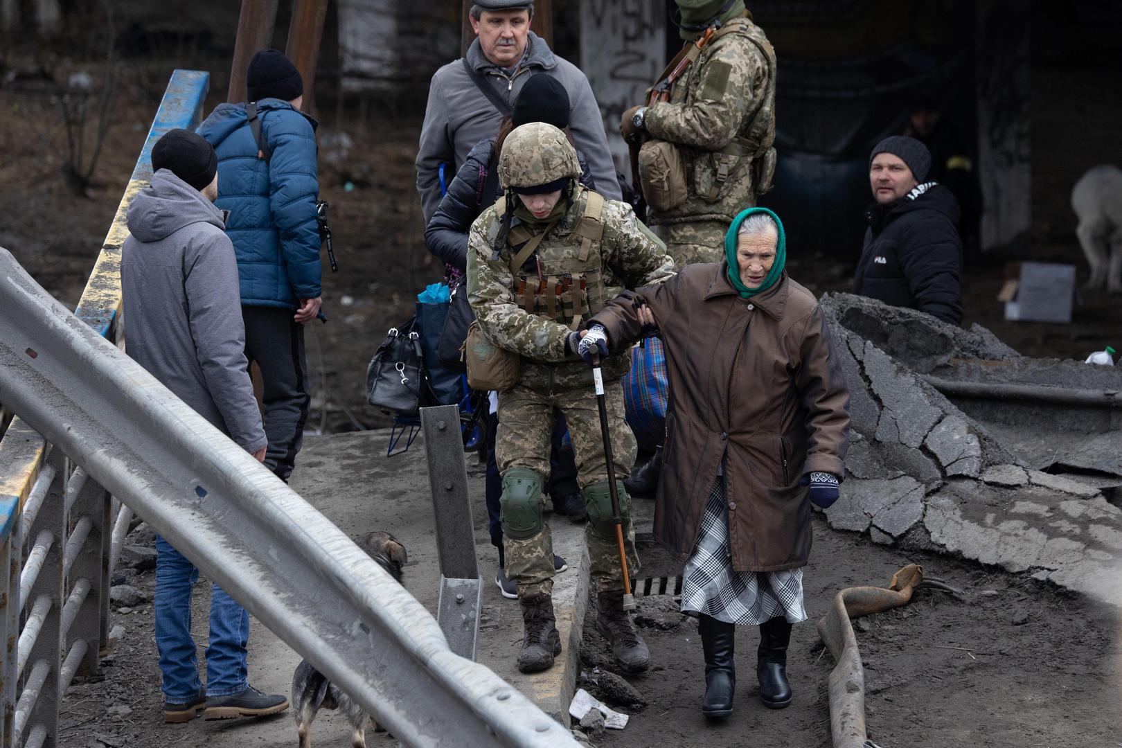 Soldiers help people cross a destroyed bridge as they evacuate the city of Irpin, northwest of Kyiv, during heavy shelling and bombing on March 5, 2022, 10 days after Russia launched a military invasion on Ukraine. Photo by Raphael Lafargue/ABACAPRESS.COM