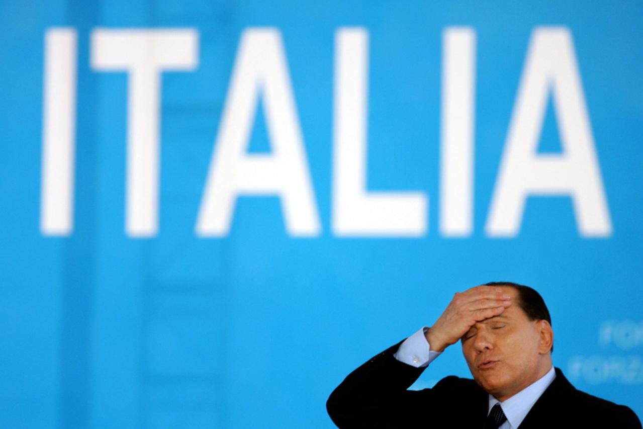 'Italian Prime Minister Silvio Berlusconi gestures as he presents his electoral programme for the April general elections, during a political meeting in Naples, southern Italy in this March 26, 2006 f
