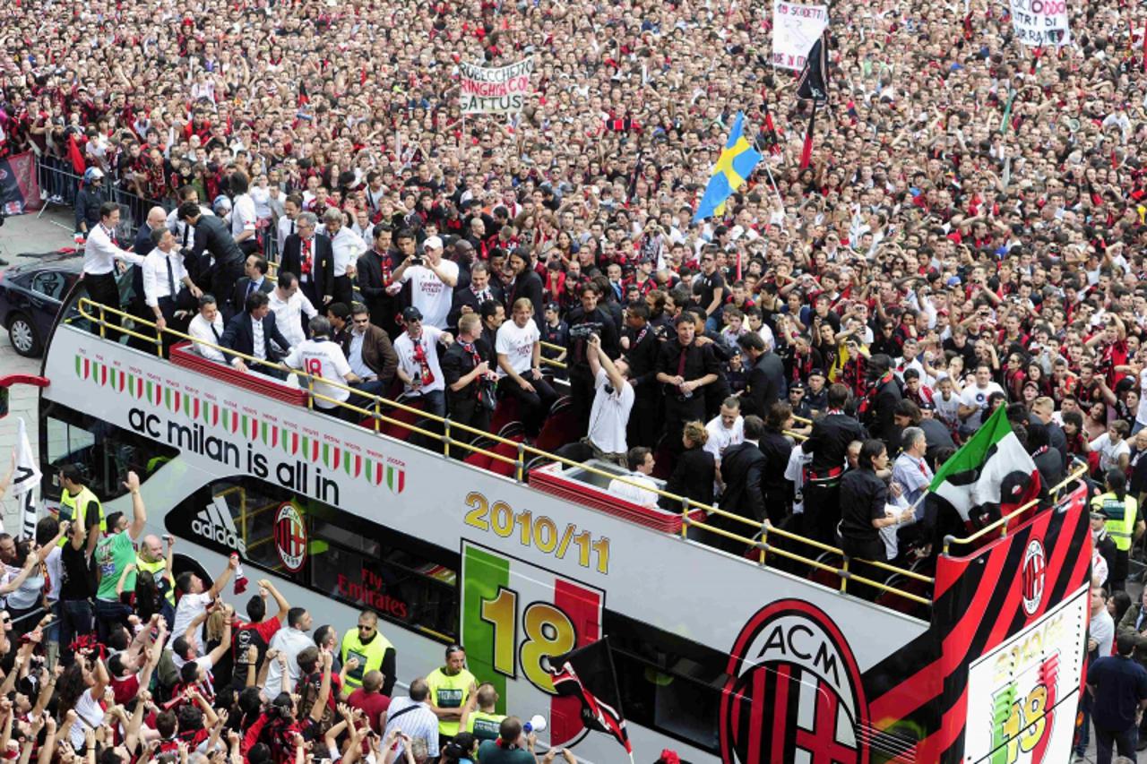 'AC Milan\'s  players and staff celebrate on a bus after the team won their 18th Italian Serie A title, in Duomo square, downtown Milan, May 14, 2011. REUTERS/Paolo Bona (ITALY - Tags: SPORT SOCCER)'