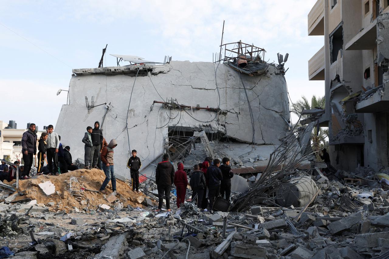 FILE PHOTO: Palestinians gather near a house hit by an Israeli strike, in Rafah in the southern Gaza Strip