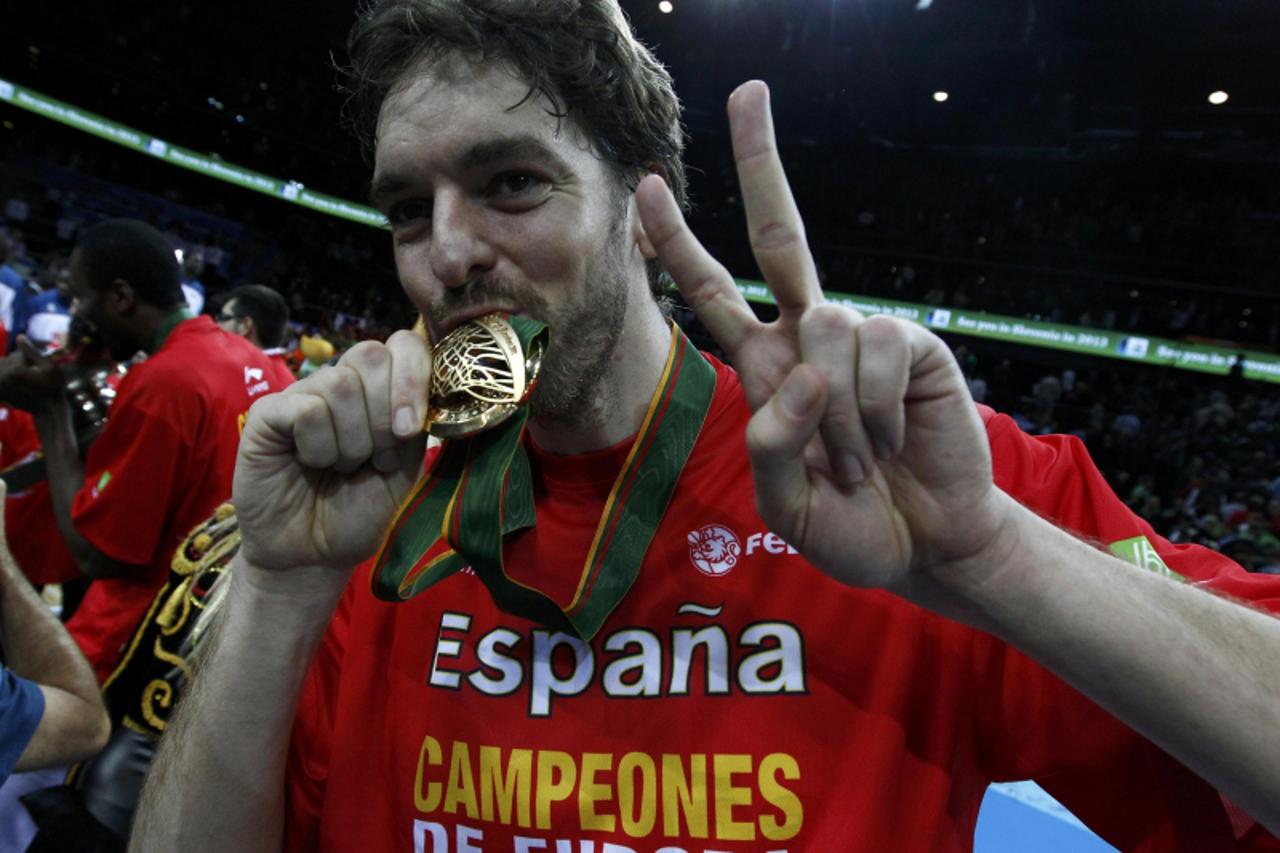 'Pau Gasol of Spain kisses his gold medal as his team celebrate after they defeated France during their FIBA EuroBasket 2011 final basketball match in Kaunas September 18, 2011. REUTERS/Ivan Milutinov