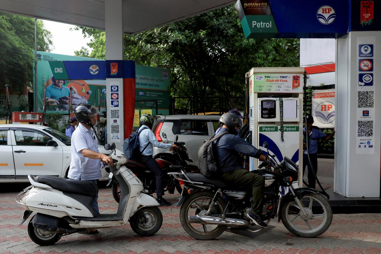 People line up to fill their vehicles with petrol at a fuel station in New Delhi
