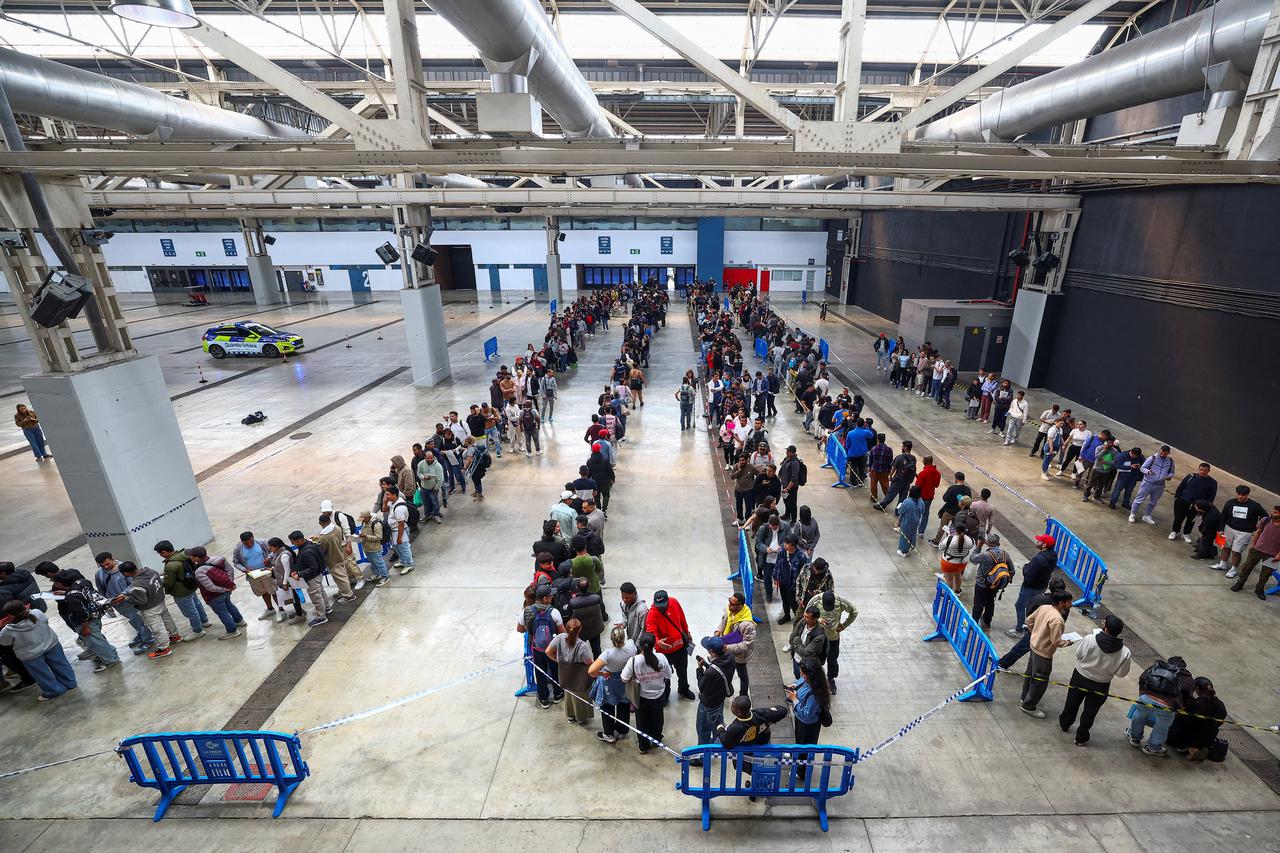 People queue to receive documentation as Spain's mass migrants regularisation process is set to start, in Hospitalet de Llobregat, near Barcelona