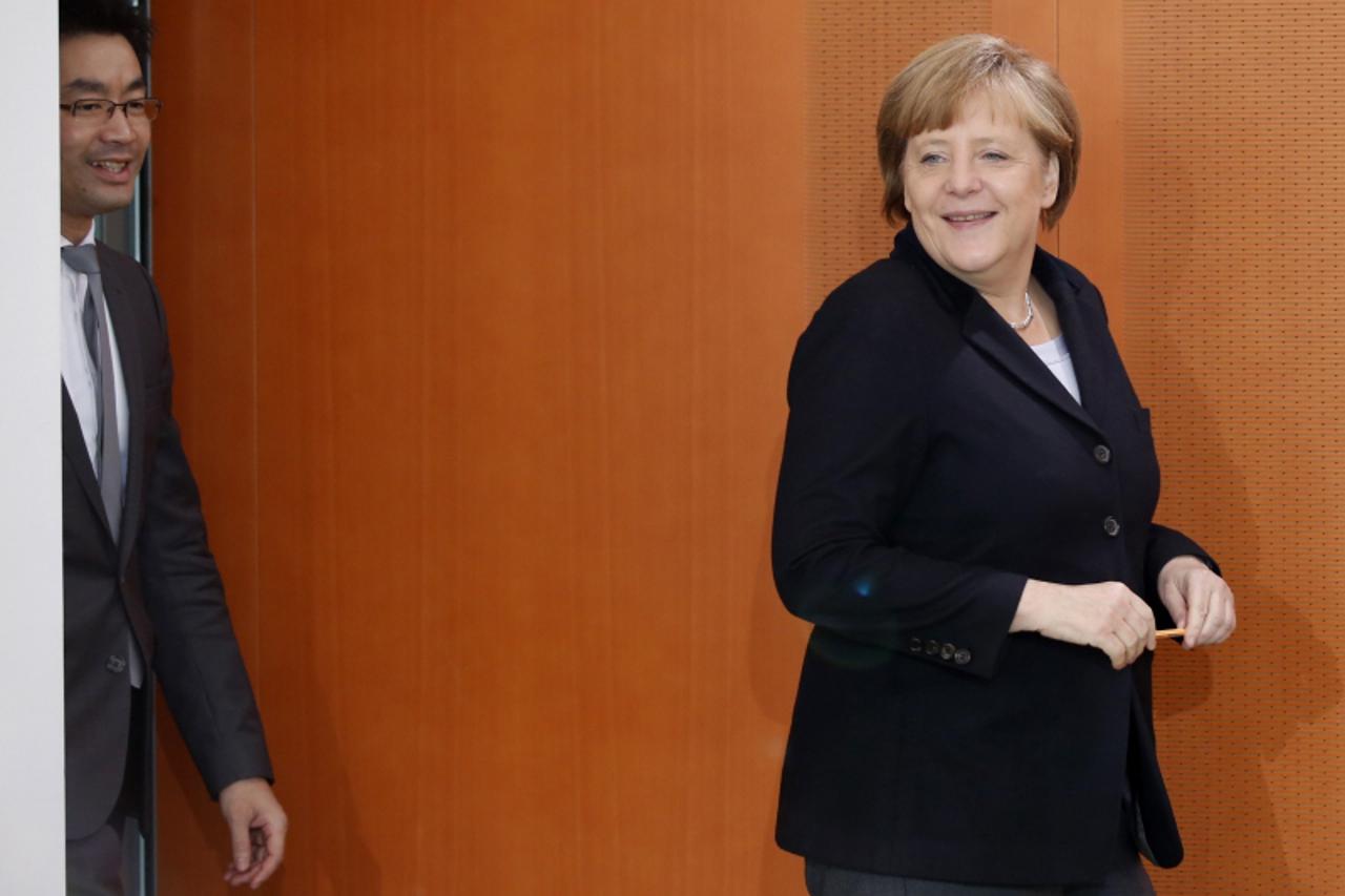'German Chancellor Angela Merkel and Economy Minister Philipp Roesler (L) arrive for the weekly cabinet meeting in Berlin, March, 20, 2013. REUTERS/Fabrizio Bensch (GERMANY - Tags: POLITICS)'