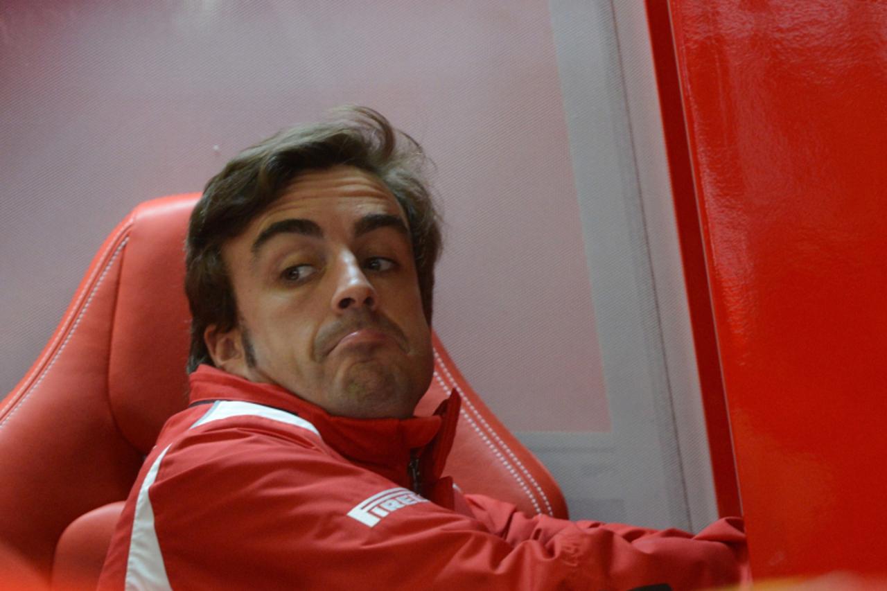 'Ferrari\'s Spanish driver Fernando Alonso stands in the pits during the first practice session at the Silverstone circuit on July  6, 2012  ahead of the British Formula One Grand Prix.  AFP PHOTO / D