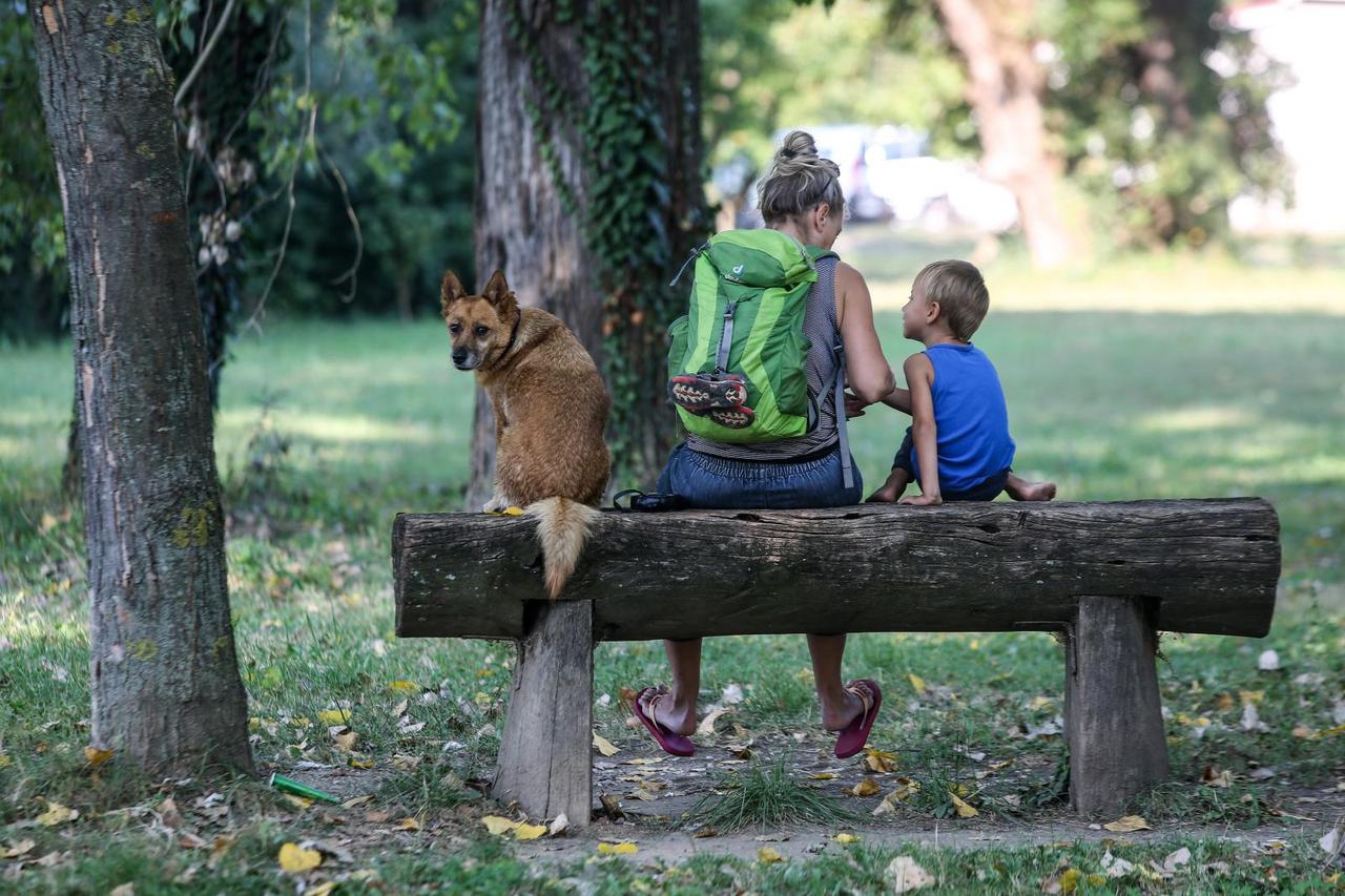 Zagreb: Pod budnim okom psa čuvara obitelj odmara na klupi uz jezero Jarun
