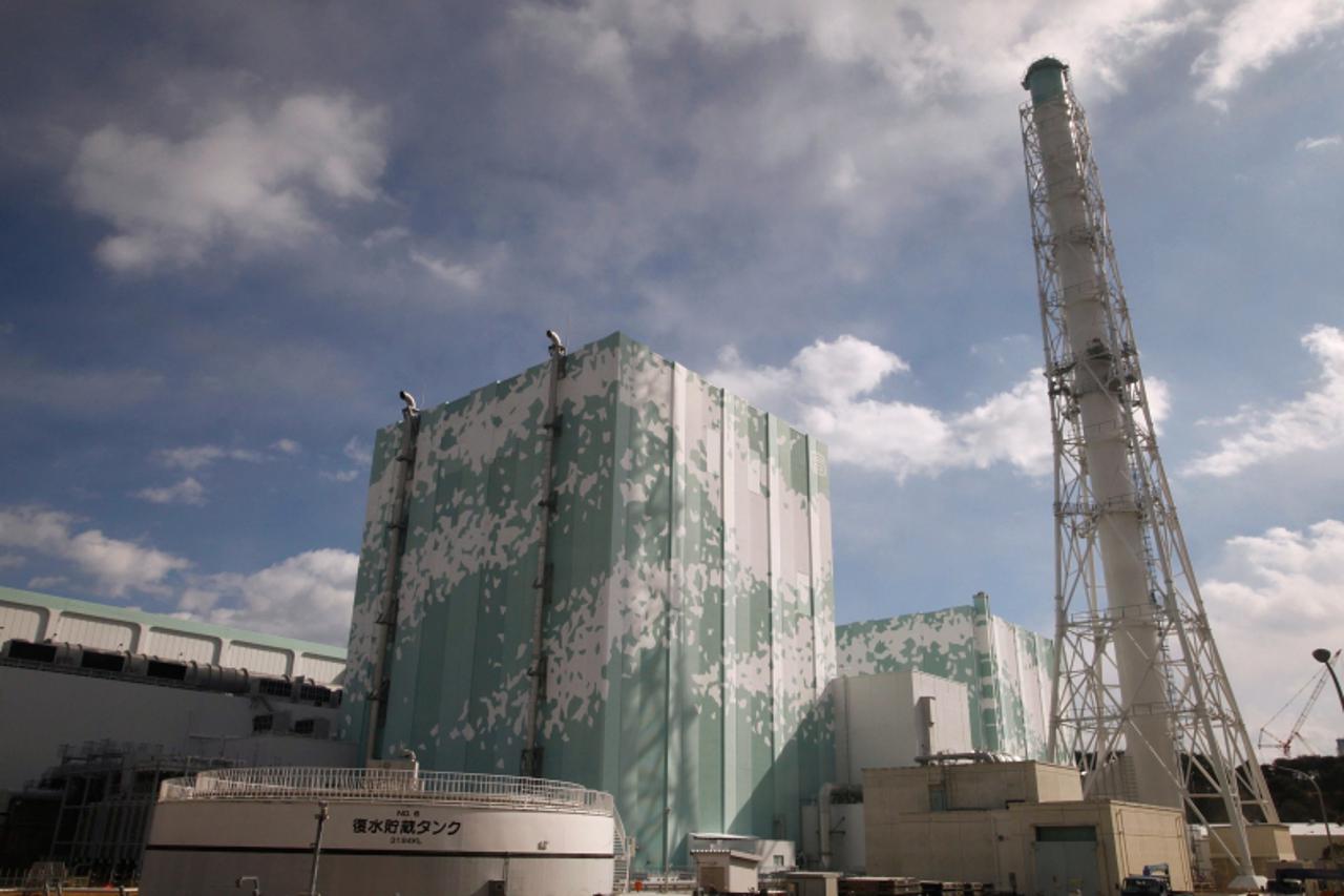 'Tokyo Electric Power Co. (TEPCO)\'s tsunami-crippled Fukushima Daiichi nuclear power plant no.6 (L) and no.5  reactor buildings are seen from the bus window during a media tour in Okuma, Fukushima pr