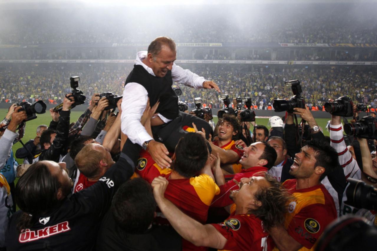 'Galatasaray\'s coach Fatih Terim and his players celebrate after winning their Turkish Super League, Super Final match against Fenerbahce at Sukru Saracoglu stadium in Istanbul May 12, 2012. Galatasa