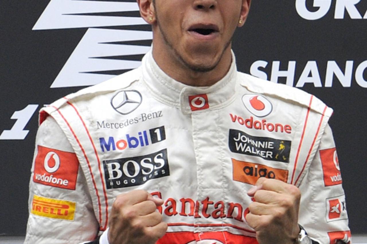 'McLaren-Mercedes driver Lewis Hamilton of Britain celebrates on the podium after winning the Formula One Chinese Grand Prix at in Shanghai on April 17, 2011. AFP PHOTO / LIU JIN'