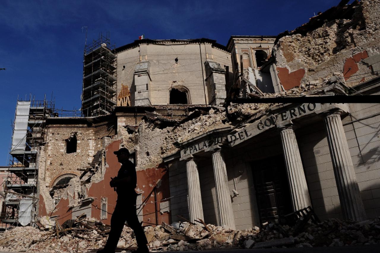 \'A policemen walks around the ruins of downtown L\'Aquila before the visit by Italian Prime Minister Silvio Berlusconi and US President Barack Obama to view the damage done to central L\'Aquila by an