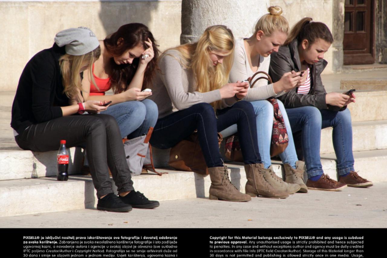 '09.11.2012., Pula - Grupa mladih djevojaka ispred gradske palace u Puli krate vrijeme mobilnim telefonima.   Photo: Dusko Marusic/PIXSELL'