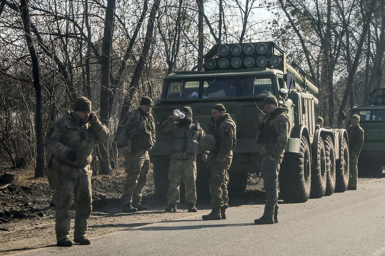 Ukrainian army soldiers stand next to multiple launch missile systems in Kharkiv region