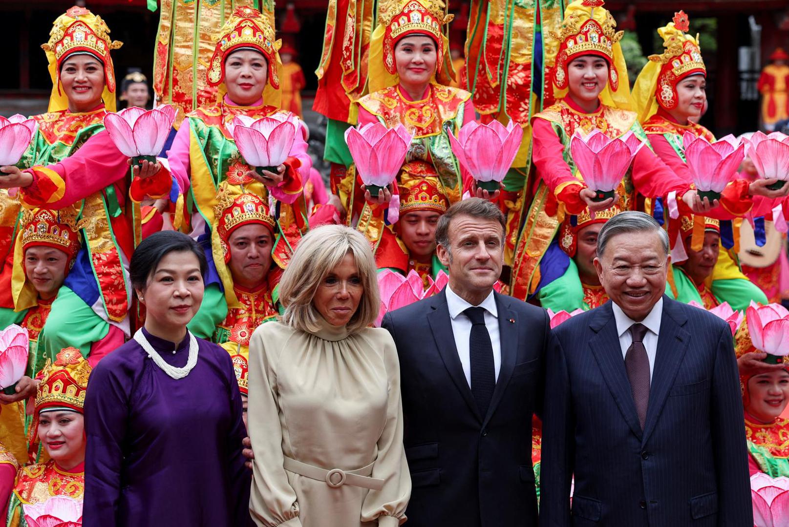 Vietnam's Communist Party General Secretary To Lam and his wife, Ngo Phong Ly, and French President Emmanuel Macron and his wife, Brigitte Macron, pose for a picture with traditional dance performers during a luncheon at Van Mieu, in Hanoi, Vietnam May 26, 2025. REUTERS/Chalinee Thirasupa/Pool Photo: CHALINEE THIRASUPA/REUTERS