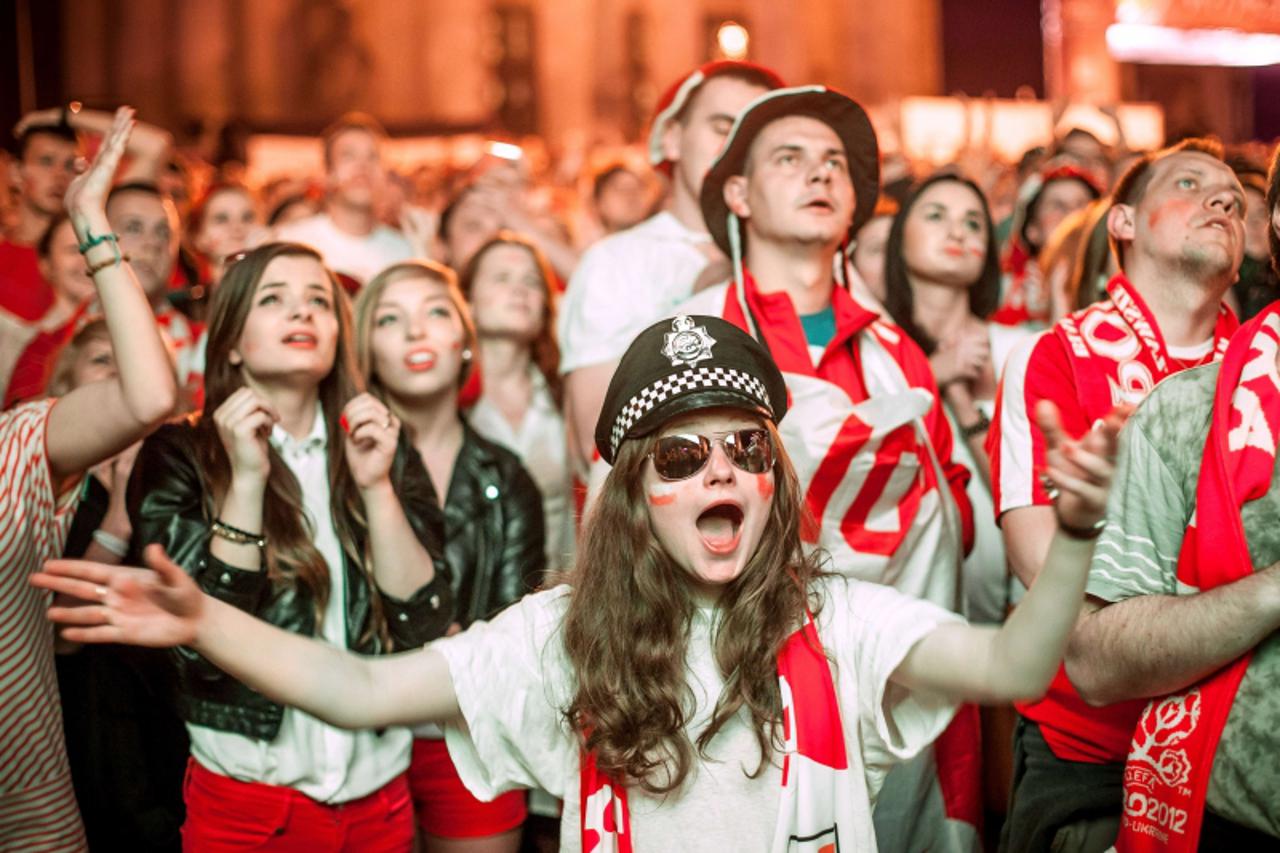 'Polish football fans cheer and shout in the Warsaw Fanzone on June 12, 2012 durng the Euro 2012 championships football match Poland vs Russia held at the National Stadium in Warsaw. AFP PHOTO/WOJTEK 
