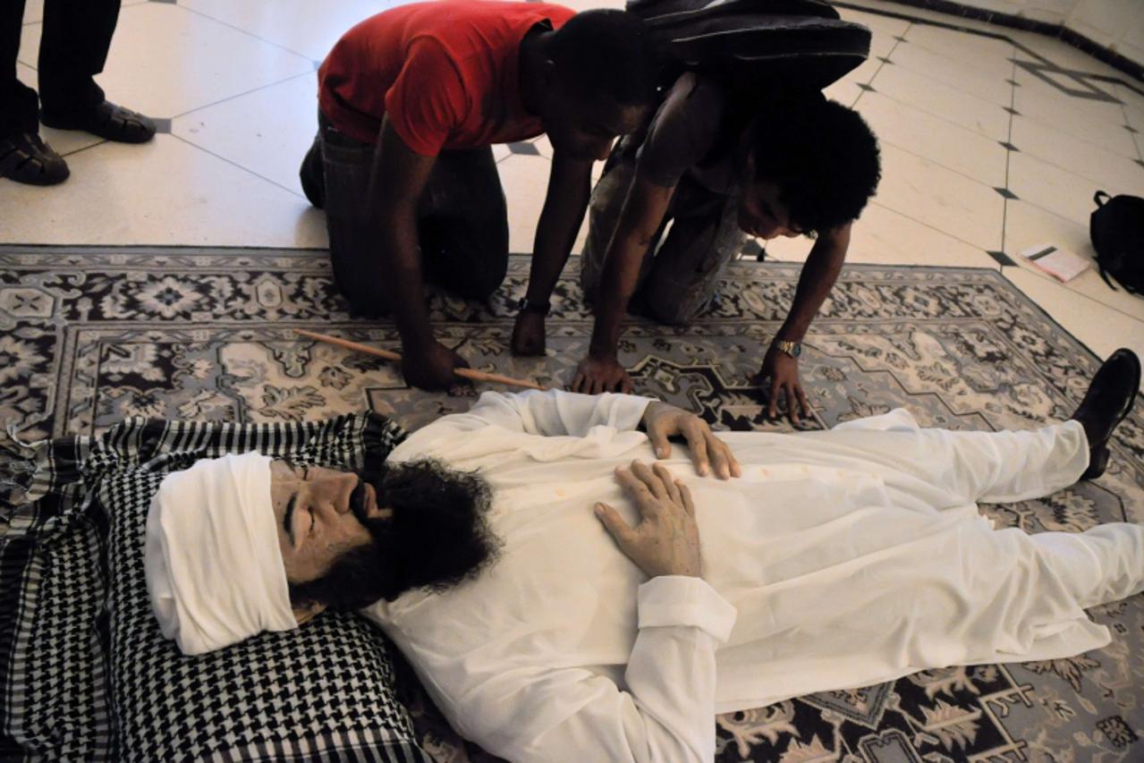 'People look at a hyper-realistic sculpture of Al-Qaeda leader Osama bin Laden by Cuban artists Julio Castro, Manolo Castro and Alberto Lorente displayed at the Superior Institute of Arts in Havana du