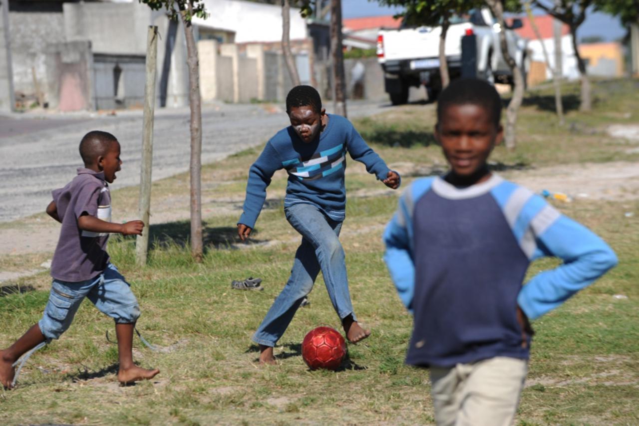 'Boys play football in the Gugulethu township outside of Cape Town on December 2, 2009. With the draw for the World Cup 2010 turning Cape Town into a hive of activity, the townships are still untouche