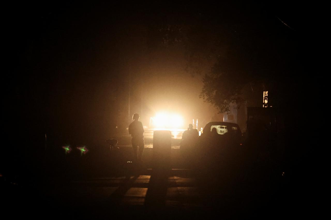 A man walks on a street during a blackout in the city of Amritsar