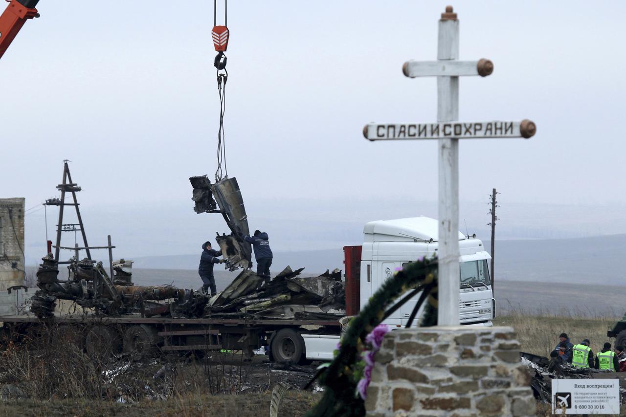 Local workers carry wreckage of the Malaysia Airlines Boeing 777 plane (flight MH17) at the site of the plane crash near the settlement of Grabovo in the Donetsk region November 16, 2014. Local emergency services have begun collecting parts of the wreckag