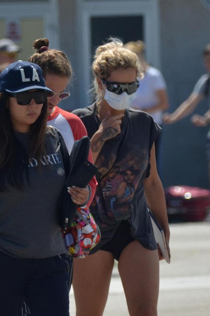 Pokušala se sakriti iza velikih sunčanih naočala i zaštitne maske za lice, no "odale" su je prepoznatljive tetovaže.