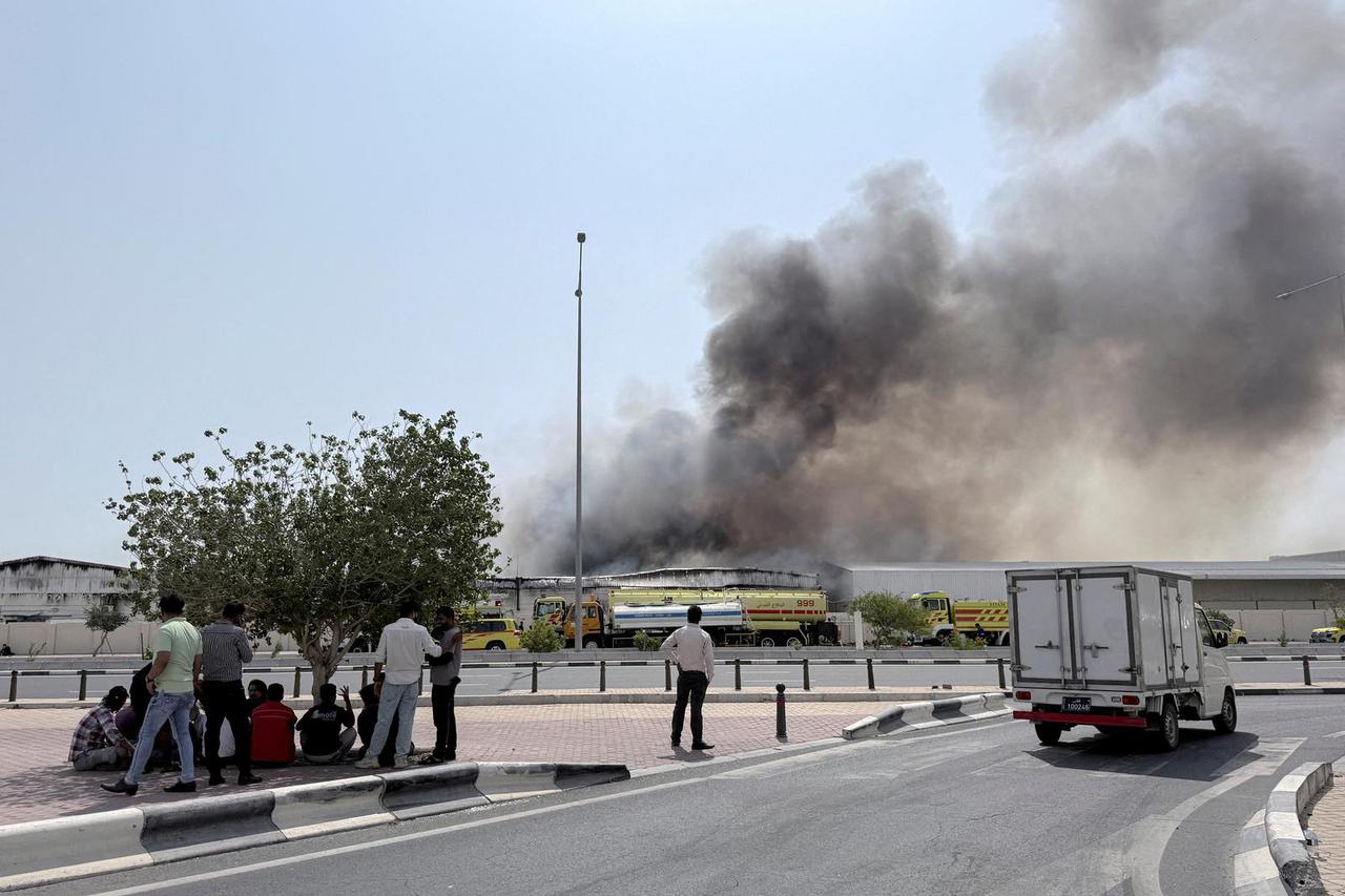 FILE PHOTO: People gather as smoke rises at the Industrial Area after reported Iranian missile attacks, following United States and Israel strikes on Iran, in Doha