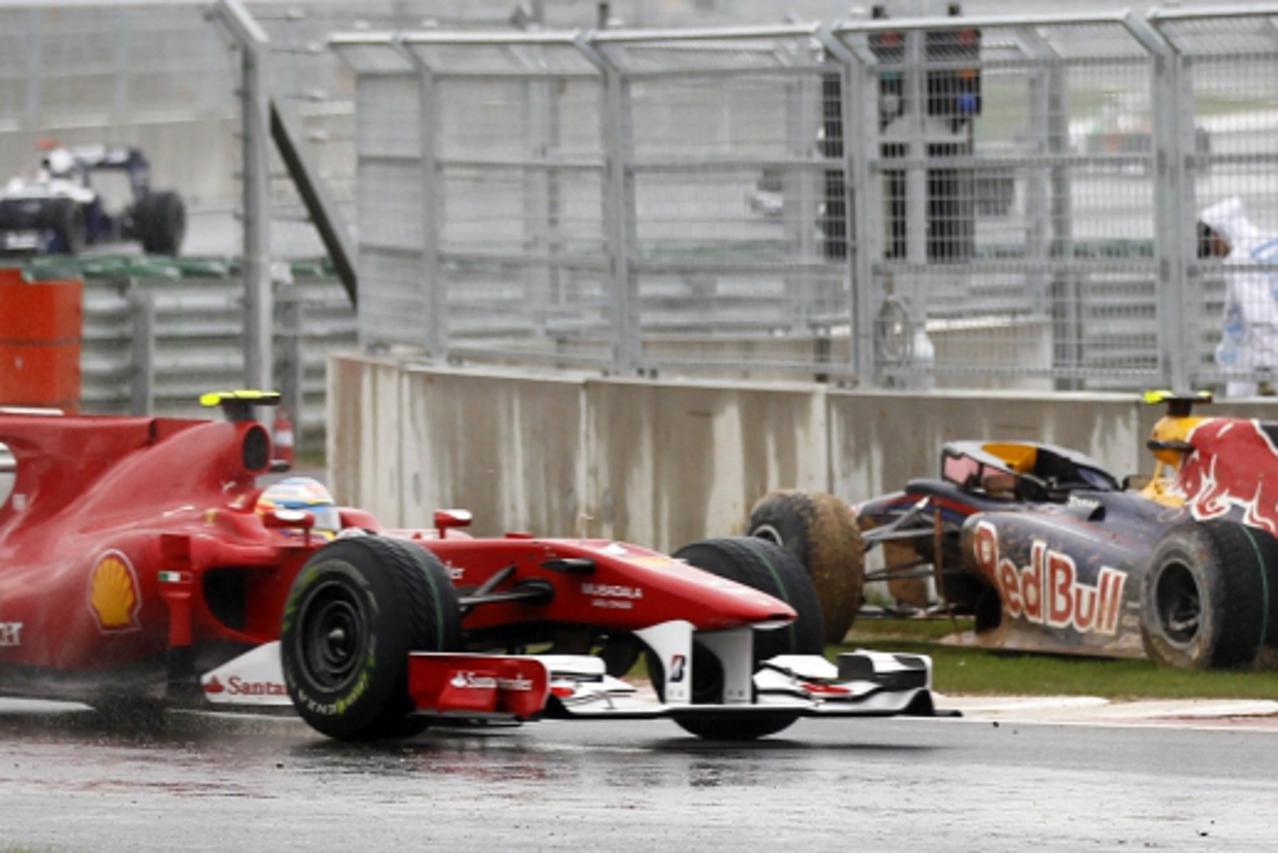 'Ferrari Formula One driver Fernando Alonso of Spain drives past the crashed car of Red Bull Formula One driver Mark Webber of Australia during the South Korean F1 Grand Prix at the Korea Internationa