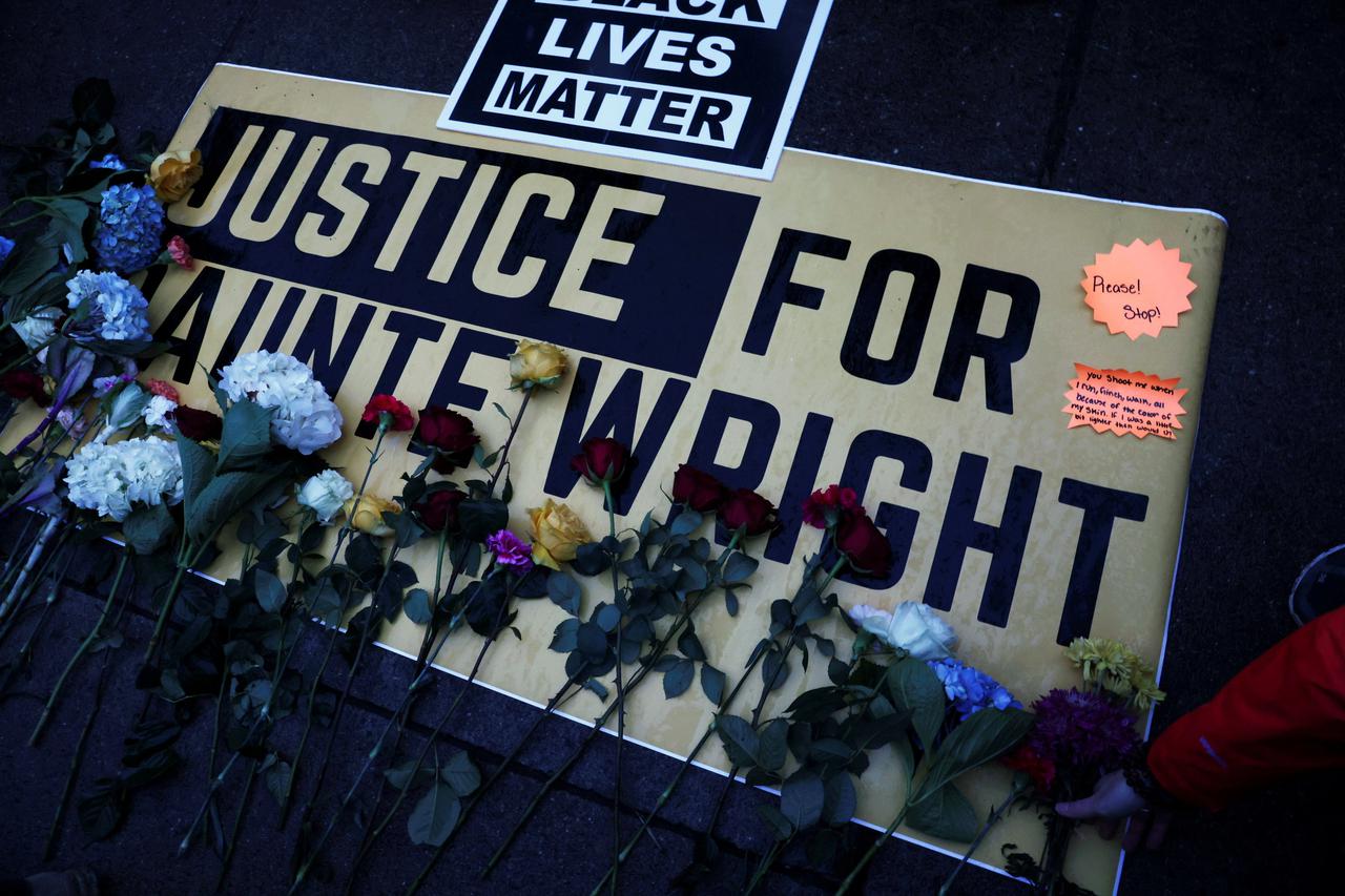 Flowers are laid on a sign as protesters rally outside the Brooklyn Center Police Department, days after Daunte Wright was shot and killed by a police officer, in Brooklyn Center, Minnesota