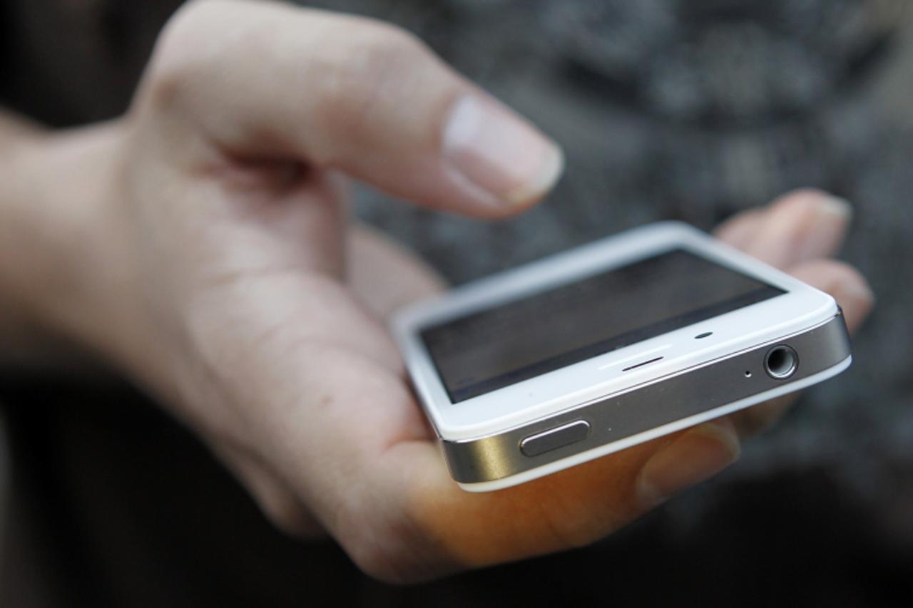'A customer uses his new iPhone 4S after making the purchase at Apple's flagship retail store in San Francisco, California October 14, 2011. Apple Inc's new iPhone 4S went on sale in stores across 