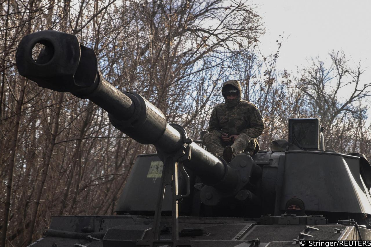 Ukrainian servicemen ride a self-propelled howitzer outside the town of Siversk
