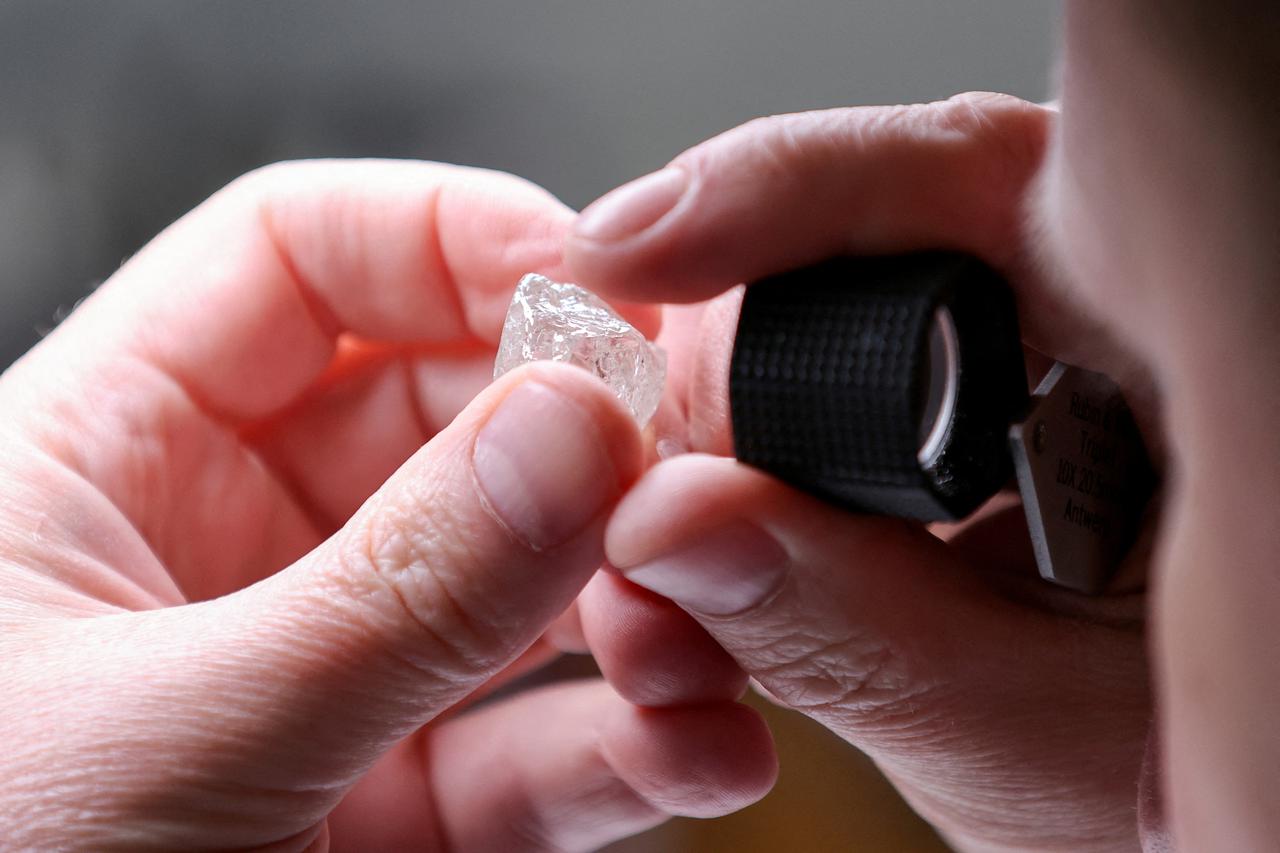 FILE PHOTO: An employee holds a rough diamond at "Diamonds of ALROSA" factory in Moscow