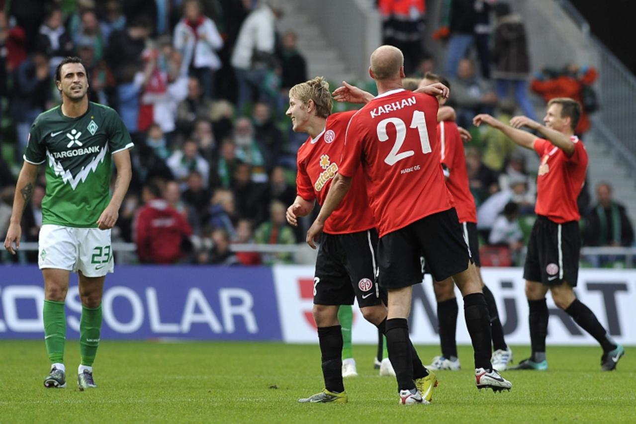 'Werder Bremen\'s Hugo Almeida (L) reacts as players of Mainz 05 celebrate after their German Bundesliga first division soccer match in Bremen, September 18, 2010. REUTERS/Morris Mac Matzen (Germany -