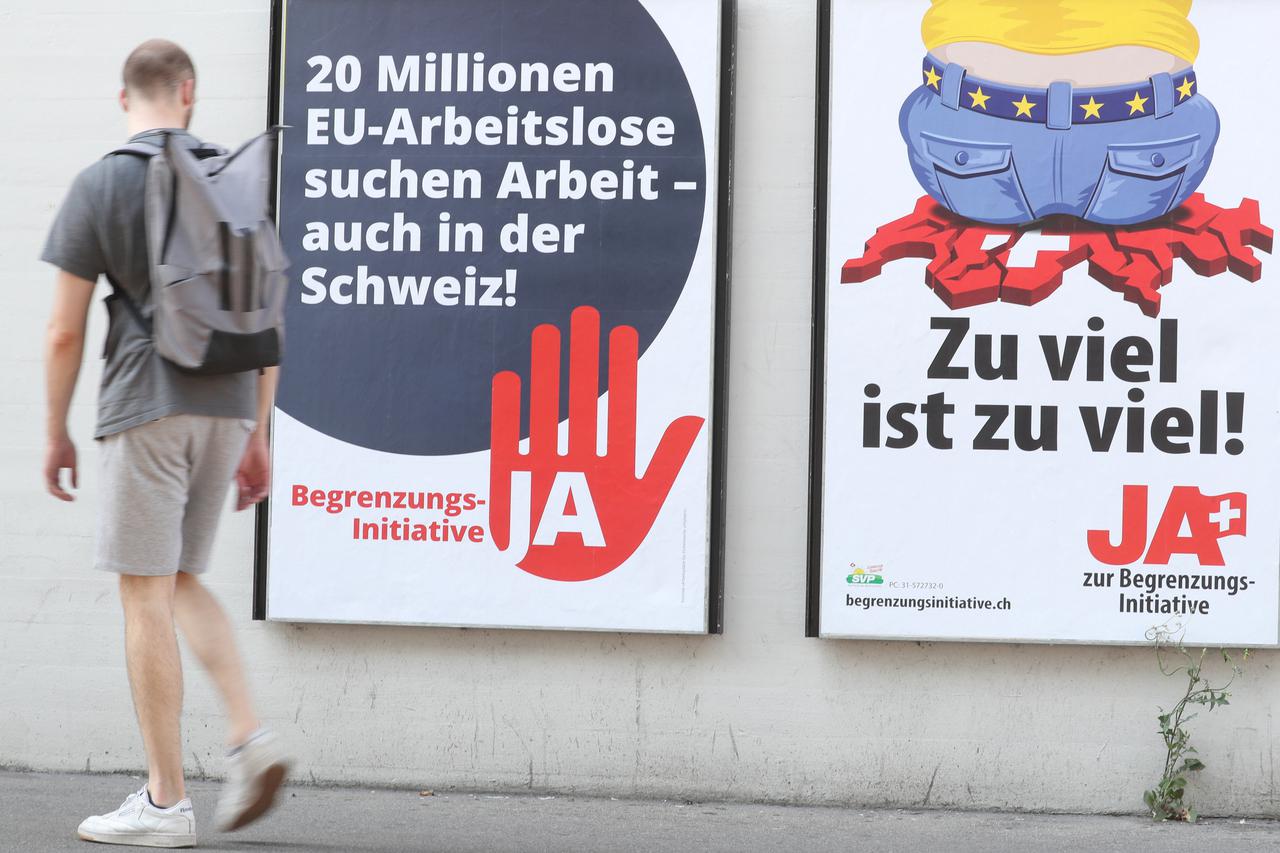 Man walks past posters against the anti-immigration initiative in Zurich
