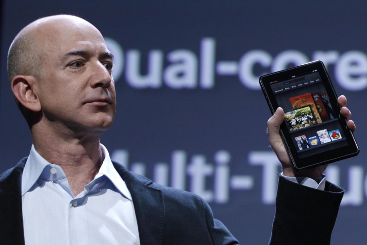 'Amazon CEO Jeff Bezos holds up the new Kindle Fire at a news conference during the launch of Amazon's new tablets in New York, September 28, 2011. REUTERS/Shannon Stapleton (UNITED STATES - Tags: BU